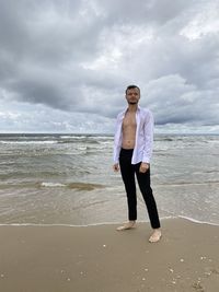 Full length portrait of man standing on beach