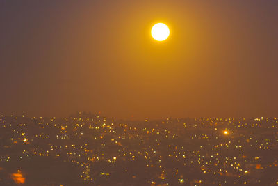 Illuminated cityscape against sky at night