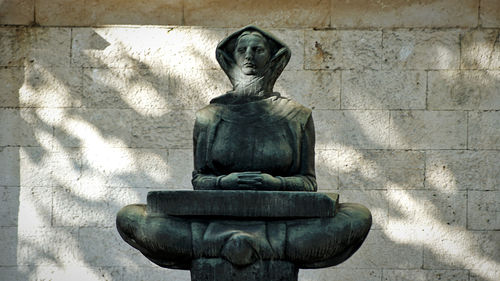 Statue of buddha against wall