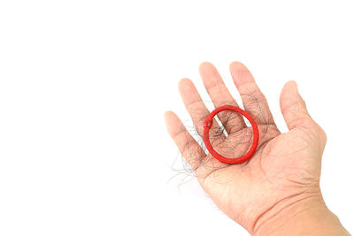 Close-up of hand holding paper over white background