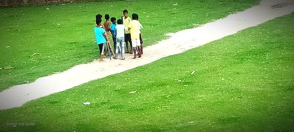 Rear view of people walking on field