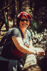 Portrait of woman wearing sunglasses sitting outdoors