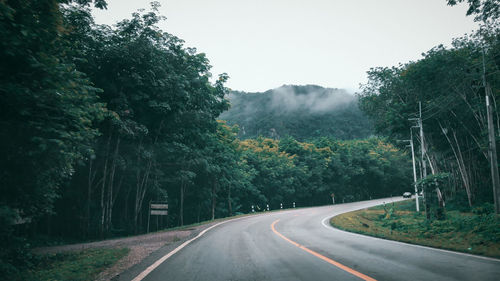 Road amidst trees against sky