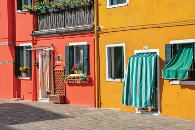 Colorful houses and doors with curtain in burano, a little town full of canals near venice, italy.