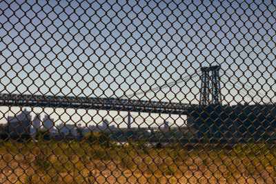 Williamsburg bridge against clear sky seen through fence