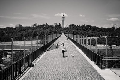 Rear view of woman on bridge against sky