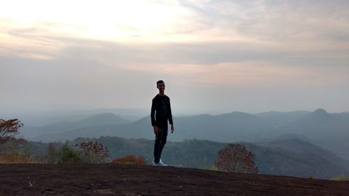 Man standing on mountain against sky