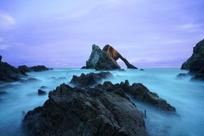 Scenic view of sea and rock formation against sky