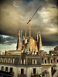 Low angle view of buildings against cloudy sky