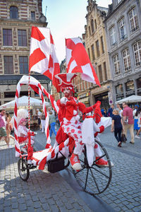 People on street against buildings in city