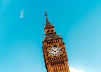 Low angle view of clock tower against blue sky