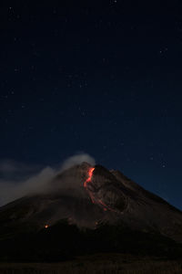 Scenic view of volcanic mountain against sky at night