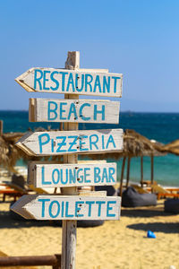 Information sign on beach against clear sky