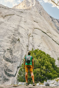 Young man looking up to el capitan mountain in yosemite national park.