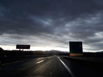 Empty road against cloudy sky