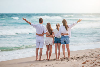 Rear view of couple standing at beach