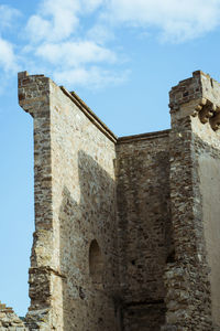 Low angle view of old building against cloudy sky