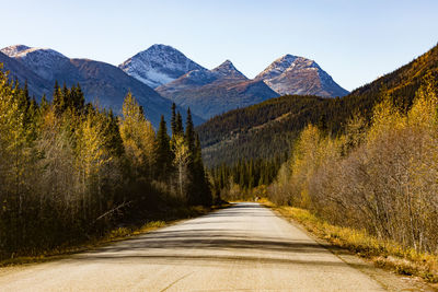 Road amidst plants and mountains against sky