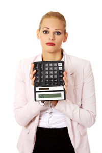 Portrait of a young woman standing against white background
