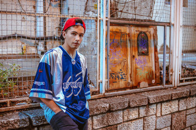 Portrait of boy standing against built structure