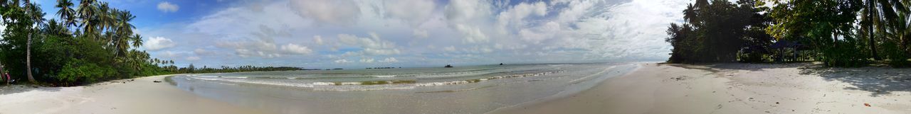 Scenic view of beach against cloudy sky