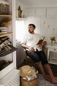 Men reading book in trailer, while traveling by camper motor home