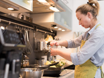 Side view of woman making food at home