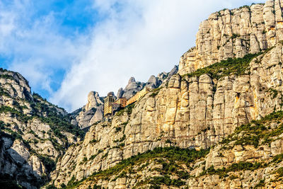 Low angle view of mountain against cloudy sky