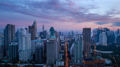 Modern buildings in city against sky during sunset