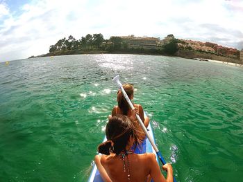 Rear view of woman in sea against sky