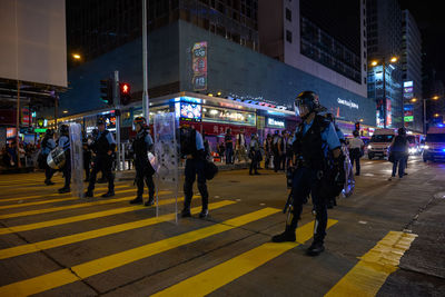 People walking on city street at night