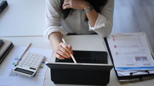 Midsection of woman using laptop on table