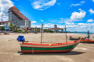 Boats moored on shore against buildings in city