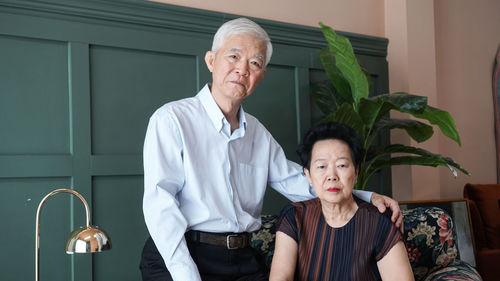 Portrait of friends standing against wall