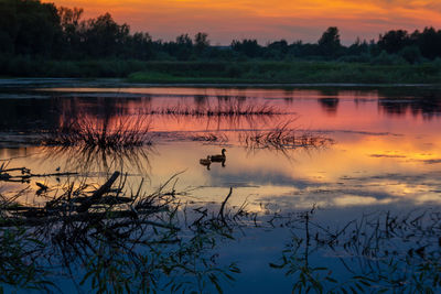 Scenic view of lake against orange sky