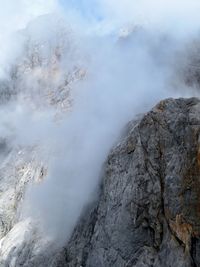 Scenic view of mountain amidst clouds