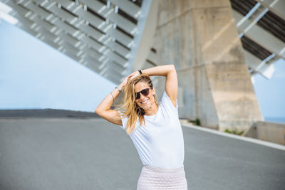 Midsection of woman with umbrella standing on road