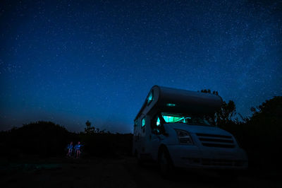 Cars on road against sky at night