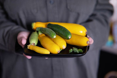 Midsection of man holding fruits