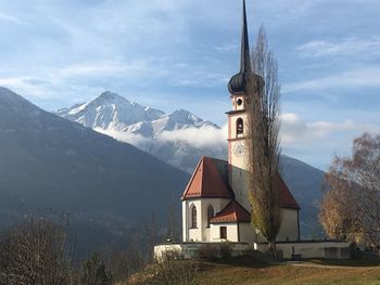 Traditional building by mountains against sky