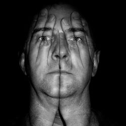 Digital composite image of hands on man face against black background