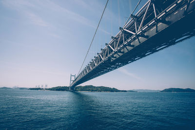 Low angle view of bridge over sea against sky