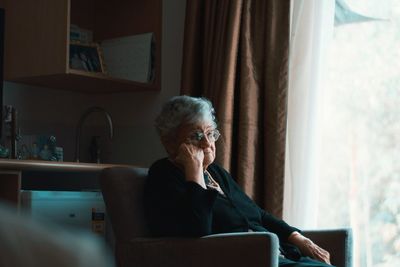 Woman looking at camera while sitting at home