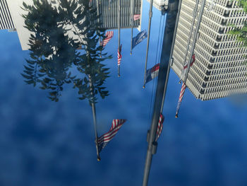 Low angle view of flags against blue sky