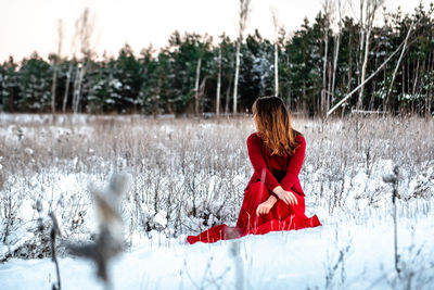 Woman with umbrella on field during winter