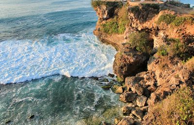 Wave hitting on the rock portrait from above the cliff