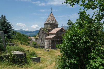 Christian monastery amidst trees and buildings against sky