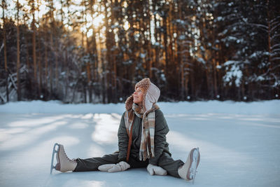 Rear view of woman standing on snow covered field