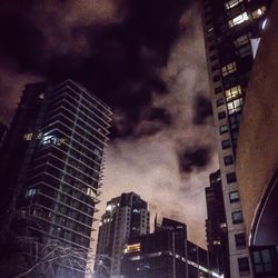 Low angle view of modern building against cloudy sky