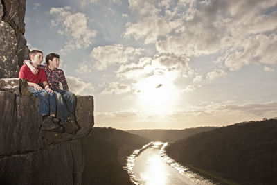 Two friends sitting on a ledge